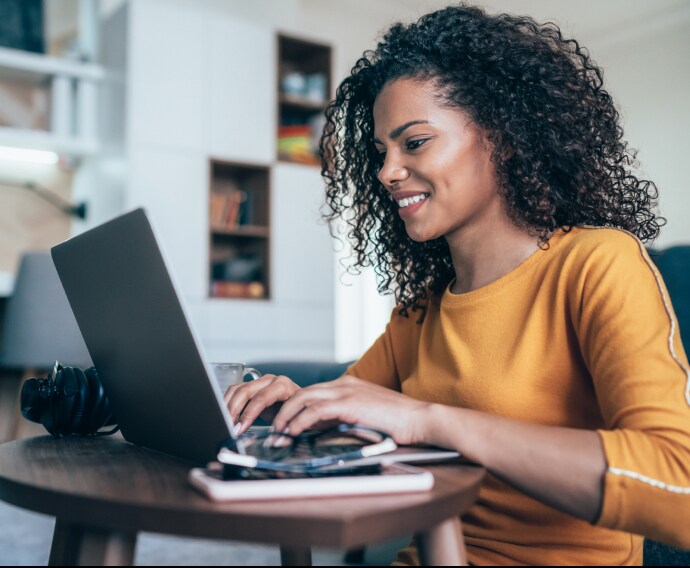 Mujer en la oficina de su casa con una computadora portátil.